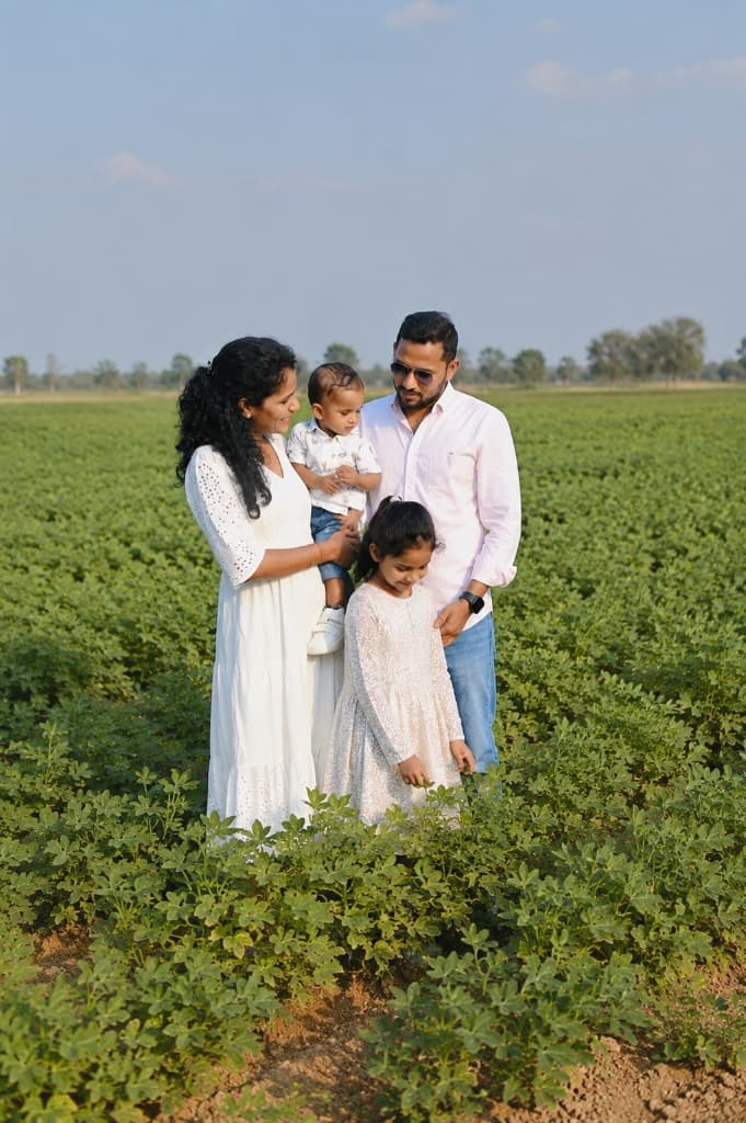 Root & Harvest founders family standing in agricultural fields under blue sky